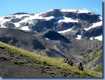 Group of riders in fron of a snowcaped mountain on a trail ride in southern Chile